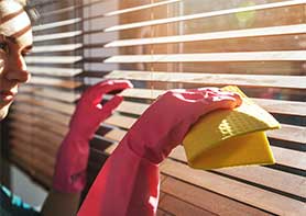 Woman Cleaning Wood Blinds