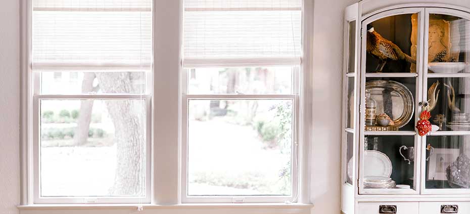 White Woven Wood Shades next to a china hutch